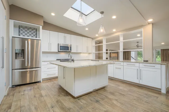 a kitchen with stainless steel appliances granite countertop a refrigerator and a stove top oven