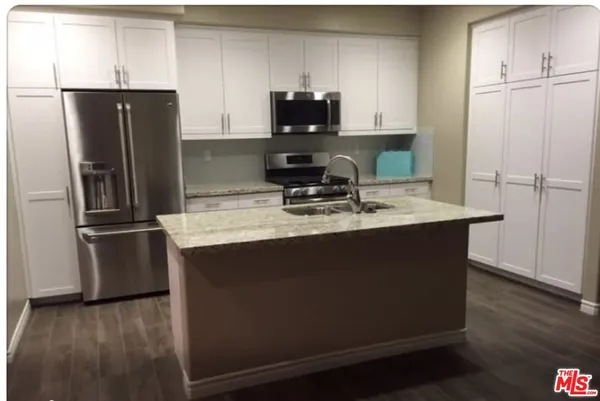 a kitchen with a refrigerator and a sink