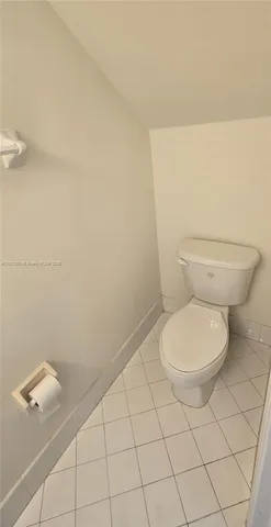 a white toilet sitting next to a white wall