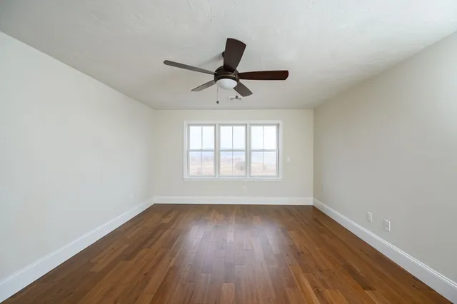a view of a room with wooden floor and windows