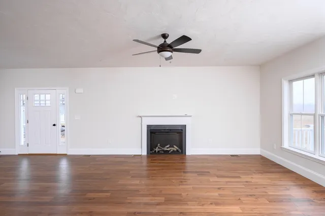 an empty room with windows and fireplace