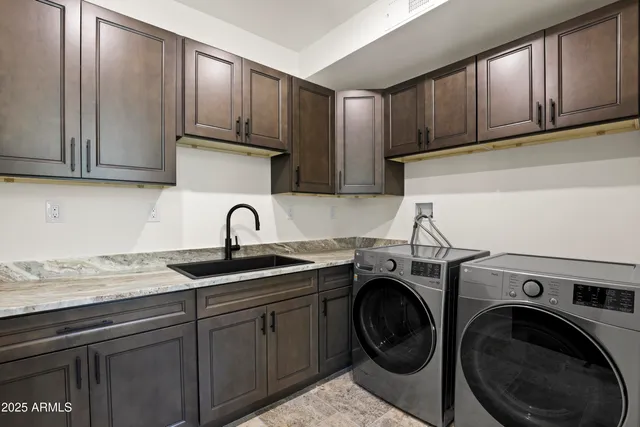 a view of a kitchen with sink washer and dryer