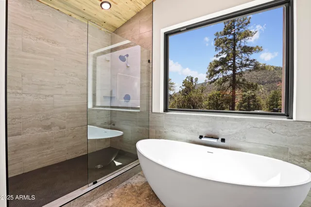 a spacious bathroom with a granite countertop sink a large mirror a bathtub and shower