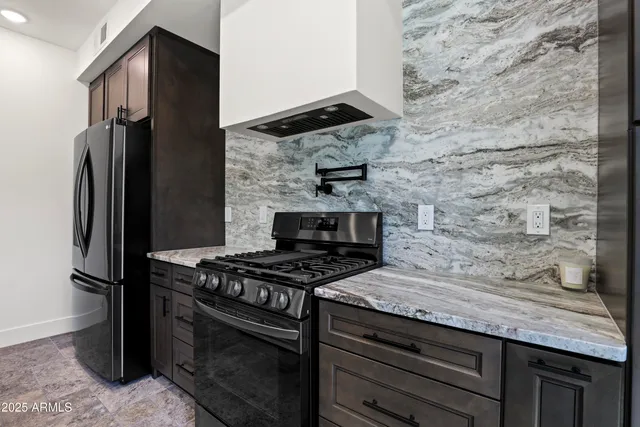 a kitchen with granite countertop a stove and a refrigerator