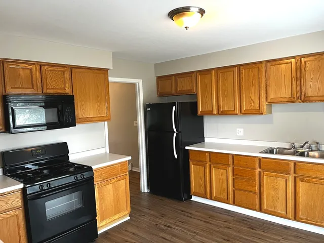 a kitchen with a refrigerator stove and wooden cabinets
