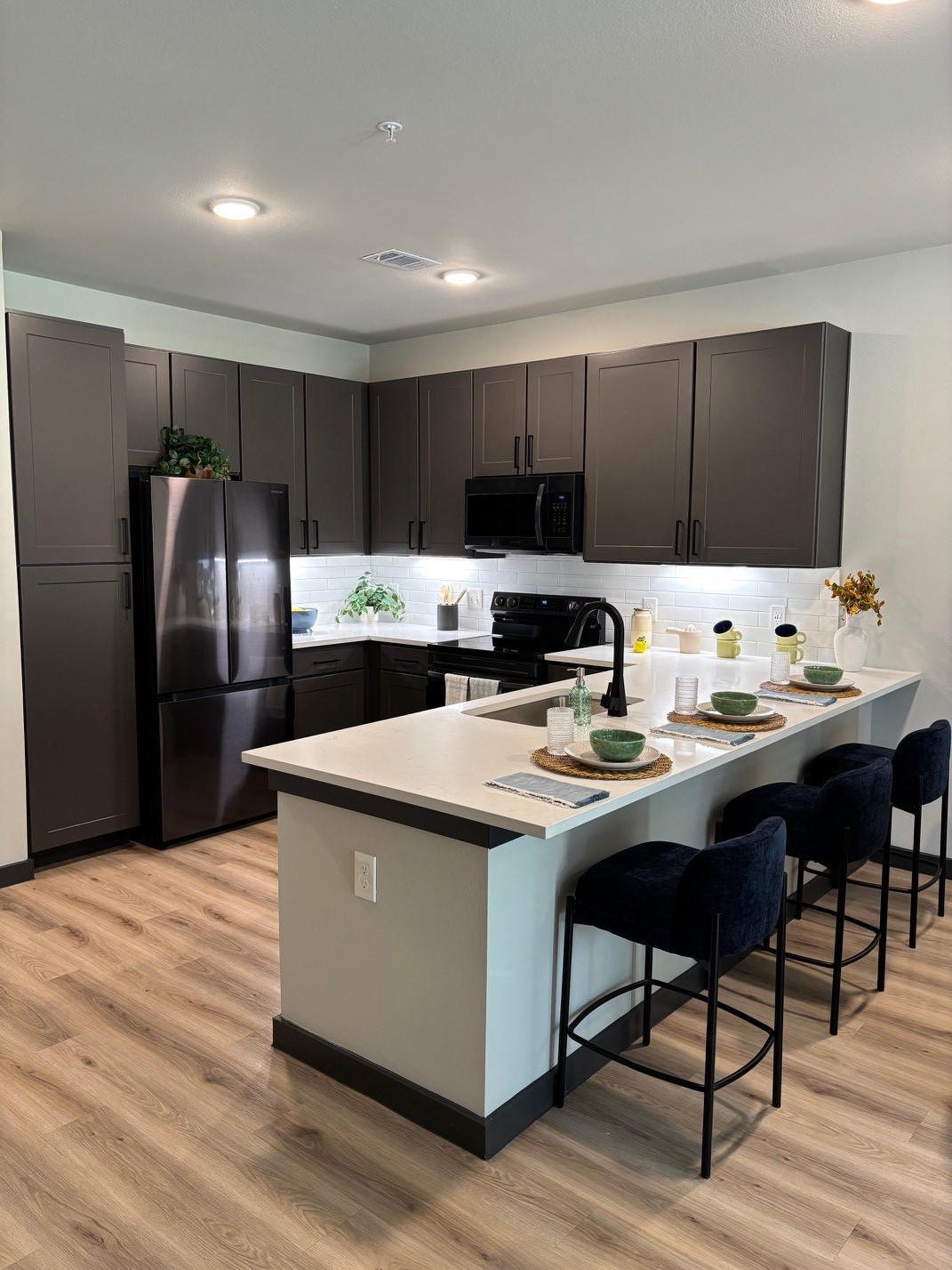 a kitchen with stainless steel appliances kitchen island granite countertop a refrigerator a stove a sink and a oven