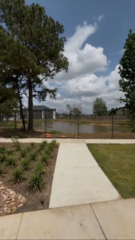 a view of backyard with swimming pool and green space