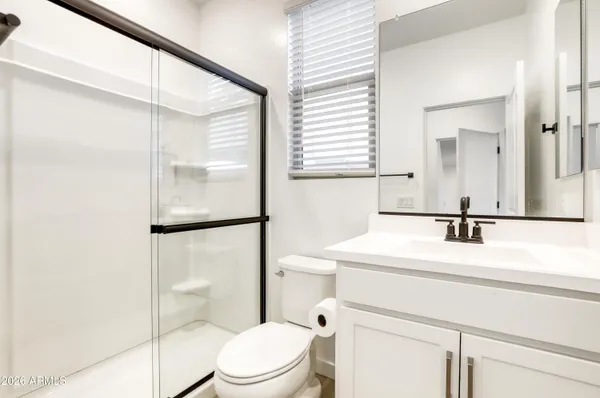 a bathroom with a sink a toilet a mirror and shower