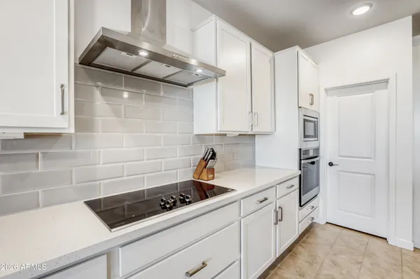a kitchen with white cabinets and white appliances