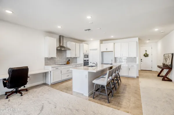 a kitchen with a table chairs a sink dishwasher and cabinets