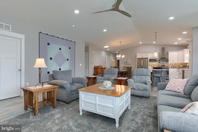 a living room with furniture and a view of kitchen