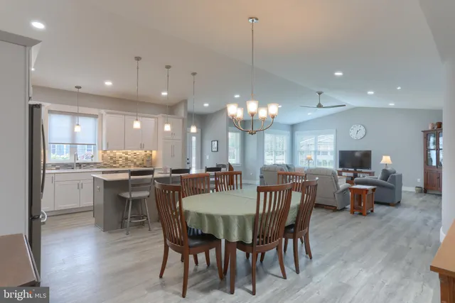 a view of a dining room with furniture a chandelier and wooden floor