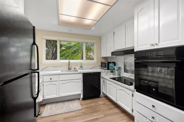 a kitchen with stainless steel appliances white cabinets and a sink