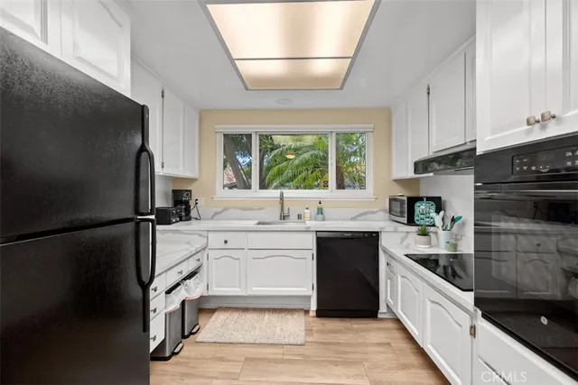 a kitchen with a sink stainless steel appliances and window
