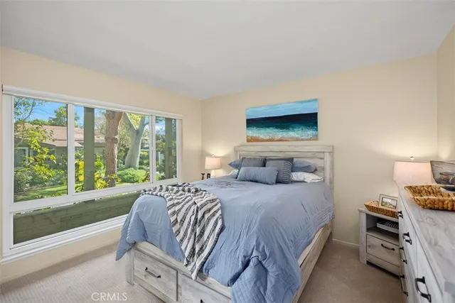 a bedroom with a bed and a large window