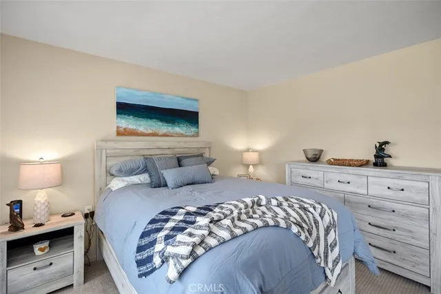 a bedroom with a bed and a lamp on dresser