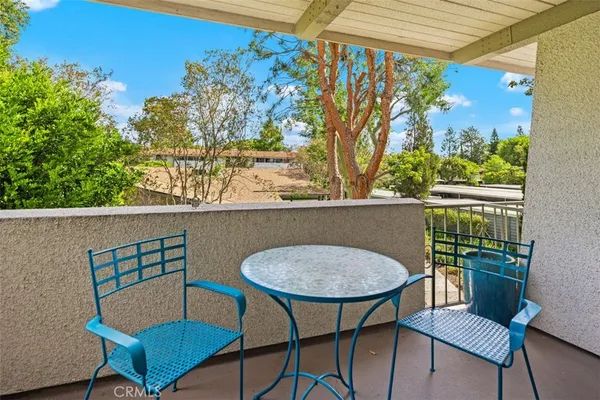a view of a chairs and table in the balcony