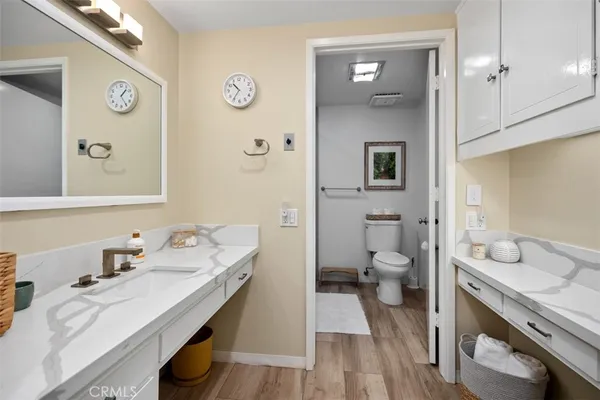 a bathroom with a granite countertop sink mirror and a toilet