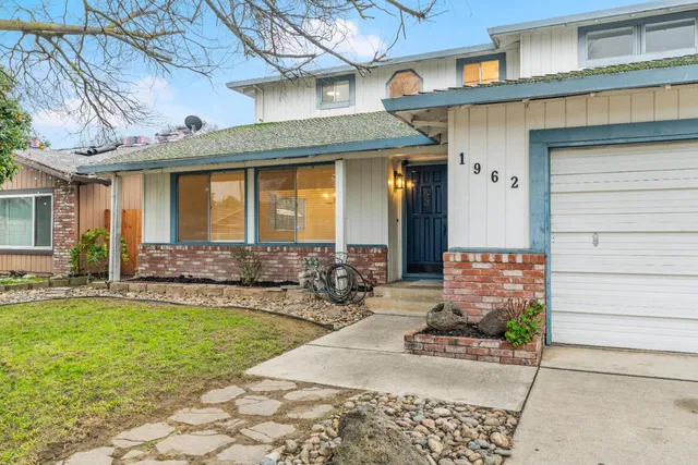 a front view of a house with a yard outdoor seating and garage