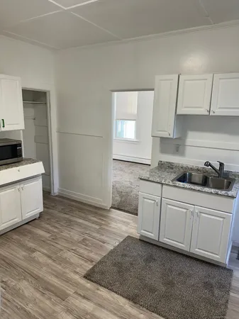 a kitchen with granite countertop a sink and a stove top oven