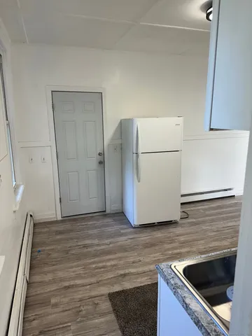 a kitchen with granite countertop a sink and a refrigerator