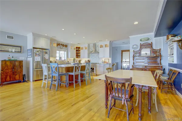 a kitchen with stainless steel appliances granite countertop a table chairs and a refrigerator