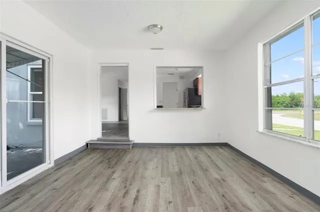 a view of a room with wooden floor and a window