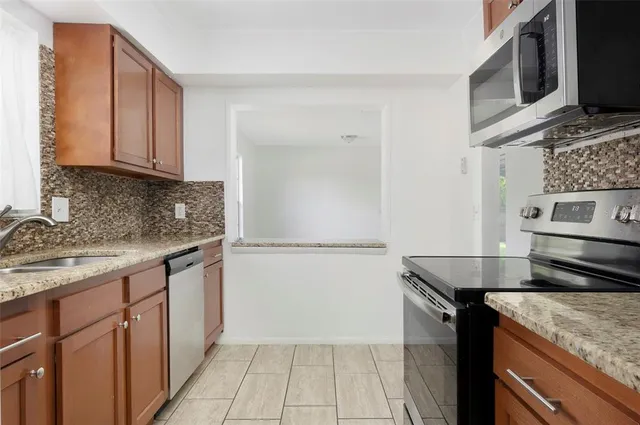 a kitchen with stainless steel appliances granite countertop a sink stove and microwave