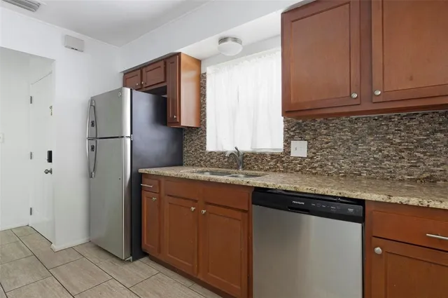 a kitchen with stainless steel appliances granite countertop a refrigerator and a sink