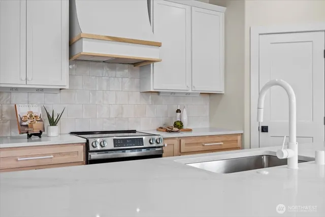 a kitchen with kitchen island a large counter top space a sink stainless steel appliances and cabinets