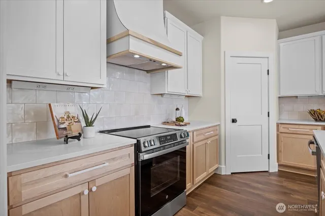 a kitchen with stainless steel appliances kitchen island granite countertop a table chairs and a refrigerator