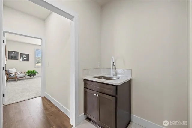 a bed sitting in a bedroom next to a window with a lamp