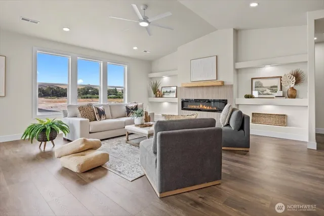a living room with furniture fireplace and a large window