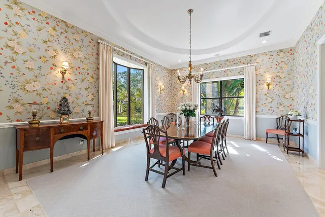 a view of a dining room with furniture one side kitchen view and wooden floor