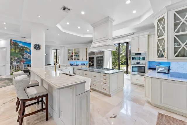 a kitchen with stainless steel appliances kitchen island granite countertop a table and chairs in it
