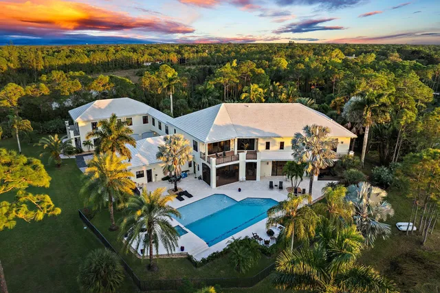 a front view of multi story residential apartment building with yard and green space