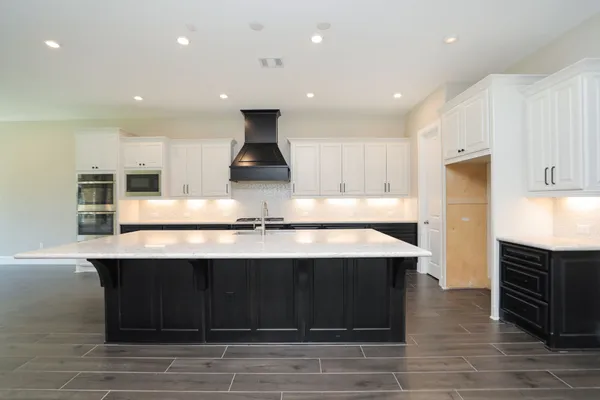 a kitchen with kitchen island stainless steel appliances a sink counter top space and cabinets