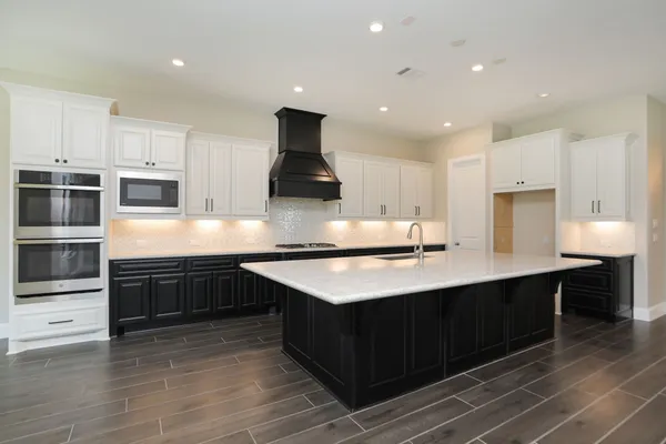 a kitchen with stainless steel appliances granite countertop a sink counter space cabinets and wooden floor