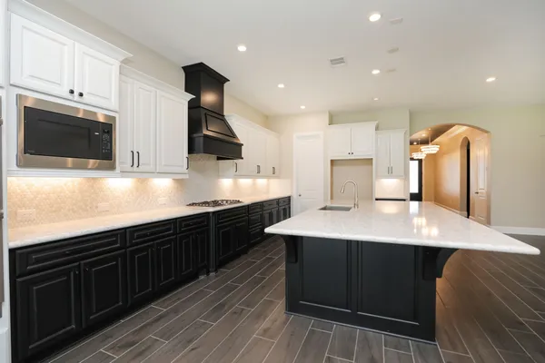 a kitchen with stainless steel appliances kitchen island granite countertop a sink a stove and cabinets