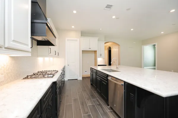 a kitchen with kitchen island stainless steel appliances sink stove refrigerator and cabinets