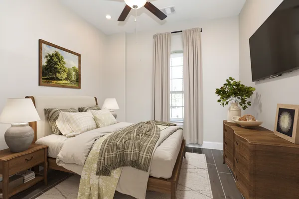 a bedroom with a bed a couch and a potted plant