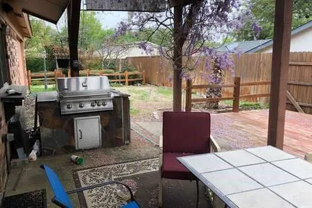 a view of a patio with table and chairs with wooden floor and fence