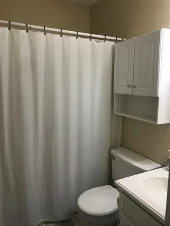 a white toilet sitting next to a shower