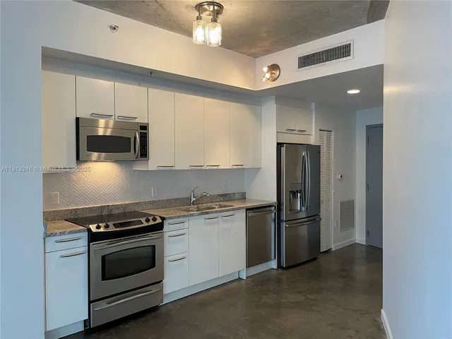 a kitchen with stainless steel appliances granite countertop a stove and a refrigerator