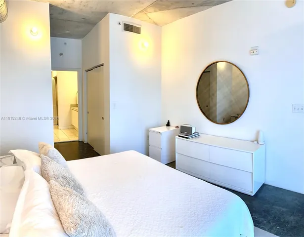 a bedroom with a bed and a painting on the wall