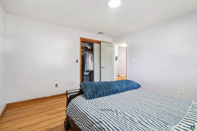 a bedroom with a bed and wooden floor