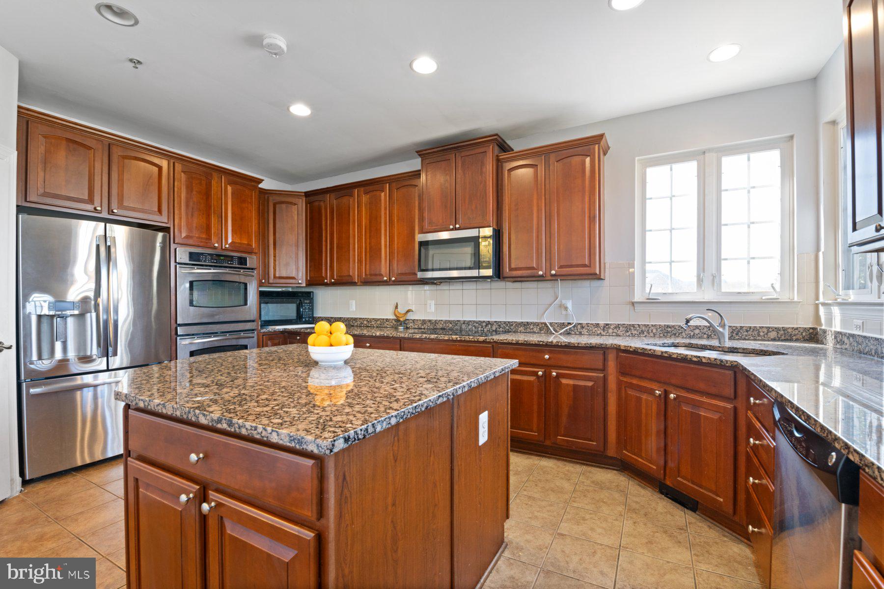 14206 Derby Ridge Road Bowie, MD 20721 - Photo 20 of 77 a kitchen with stainless steel appliances granite countertop a sink stove and refrigerator