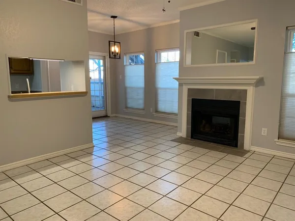 a view of an empty room with wooden floor and a fireplace