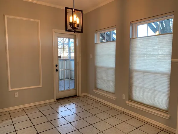 an empty room with wooden floor mirror and windows