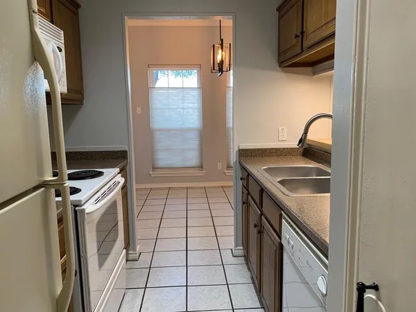 a kitchen with a sink stove top oven and cabinets